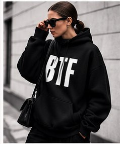 The BTF hoodie in jet black worn on a city street